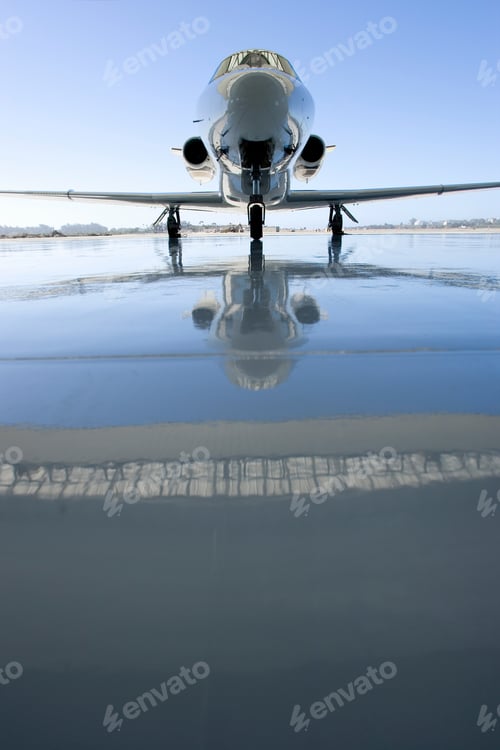 Preview: Vertical Shot Of A Modern Private Jet Plane On The Runway With A Reflection On The Ground On A