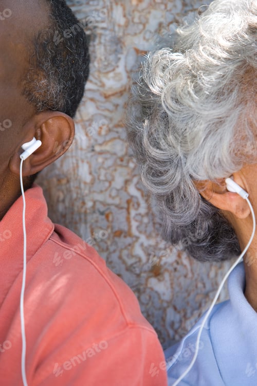 Preview: Close-Up Vertical Shot Of A Senior Couple Ear'S With Shared Earphones.