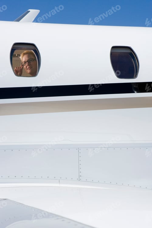 Preview: Vertical Close-Up Shot Of A Businesswoman Sitting At The Window Of A Private Jet.