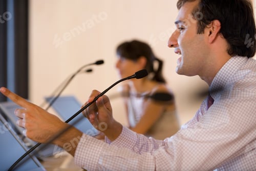 Preview: Horizontal Head And Shoulder Profile Shot Of A Businessman Speaking And Gesturing In Microphone At