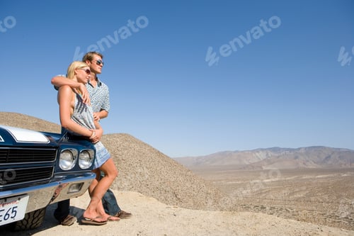 Preview: Horizontal Shot Of A Young Couple Leaning On The Car And Looking At The View In The Desert.