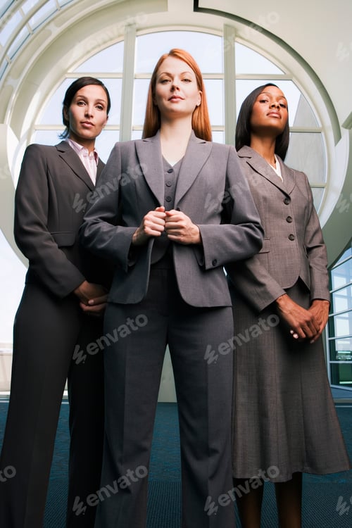 Preview: Vertical Full Length Shot Of Three Confident Businesswomen Standing In A Lobby.