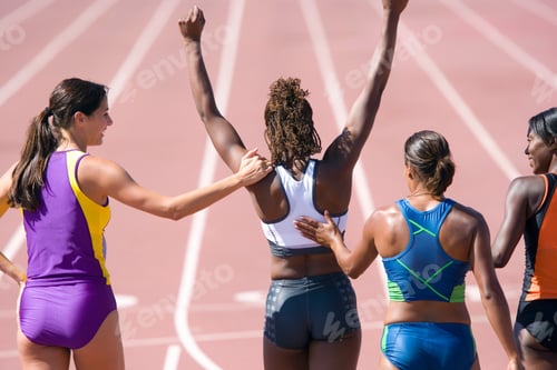 Preview: Young Female Runner Cheering Her Victory With Her Arms Raised Overhead While Her Competitors