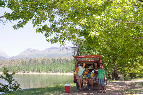 Preview: Wide Shot Of A Family In The Trunk Of A Car Under A Tree On A Sunny Day Near The Lake.