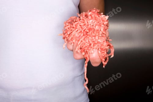 Preview: Horizontal Shot Of Woman Holding Fresh Ground Meat In A Kitchen.