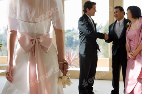 Preview: Horizontal Shot Of A Groom Talking To A Senior Couple And Shaking Hands At The Wedding In The