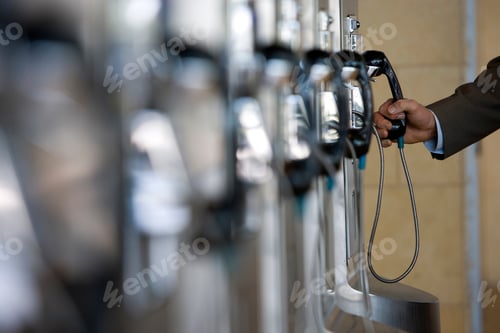 Preview: Selective Focus On A Businessman'S Hand Holding The Receiver Of A Public Payphone With Copy Space.
