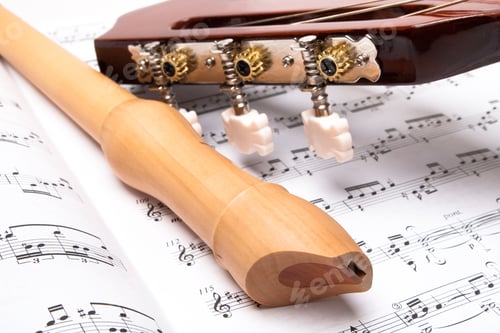 Preview: Guitar And Wooden Flute On Sheet Music. Close Up.