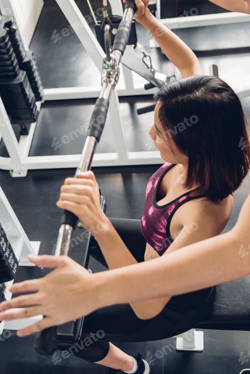 Preview: Attractive Woman Doing Exercise With Personal Trainer At Gym.