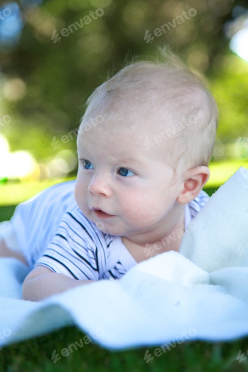Preview: Young Baby On His Stomach On A Blanket Outdoors.
