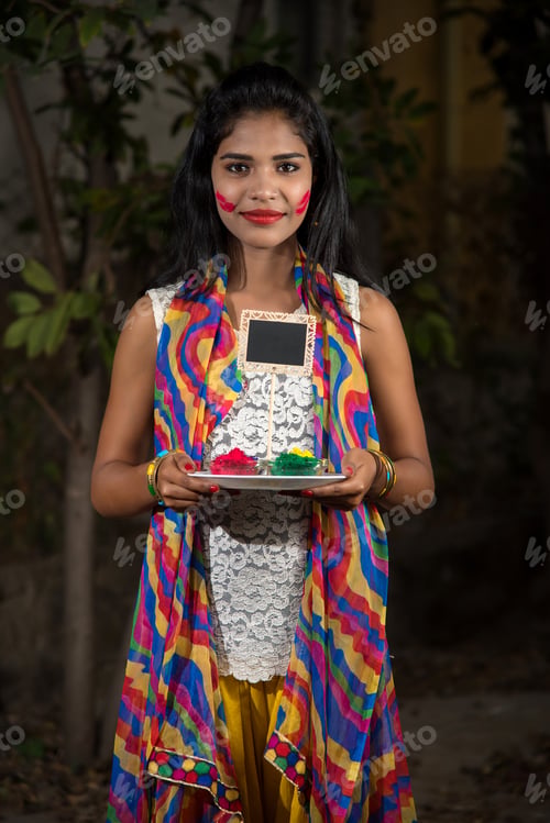 Preview: Young Girl Holding Small Board With Powdered Colors On The Occasion Of Holi Festival With Faces