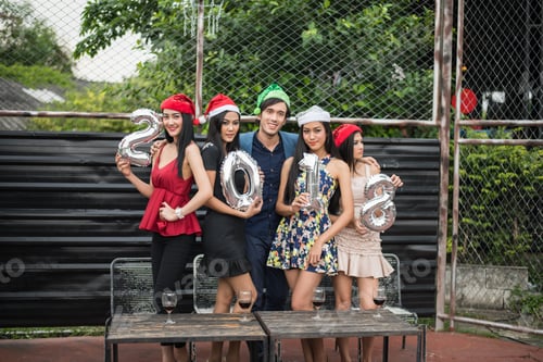 Visualização: Jovens segurando vidros conversam na festa.