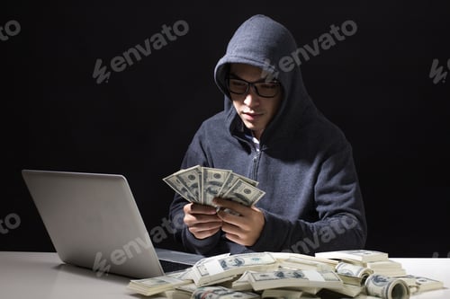 Preview: Hacker Holding Money That Hacking From Online In The Dark, Man With Hacker Concept.