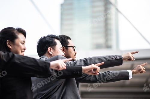 Preview: Colleagues Pointing While Standing Against Buildings In City