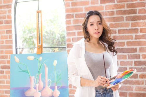 Preview: Asian Woman Paints Picture On Canvas With Oil Paints. Woman Painting Picture With Attractive