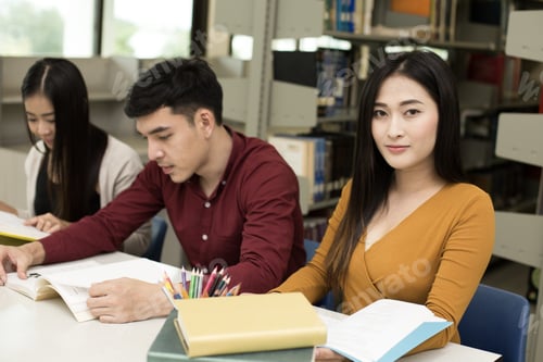 Preview: Group Of Student Reading Books In The Library With Attractive Smiling Together . People With