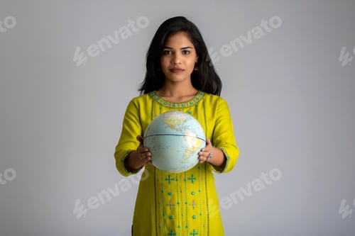 Preview: Young Girl Holding The World Globe And Posing On A Grey Background.