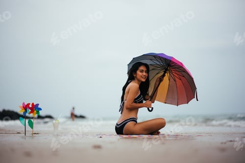 Preview: Beautiful Asian Woman On Beach Summer Vacation In Bikini Sitting On Sand In Holiday.
