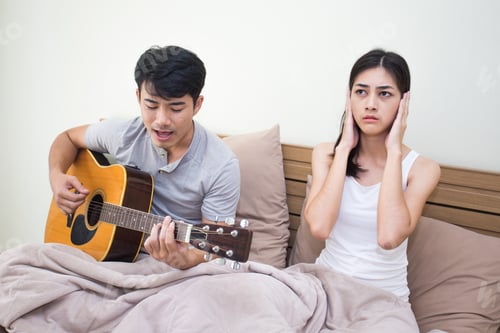 Preview: Asian Woman Annoyed At A Man Who Is Singing And Playing A Guitar.
