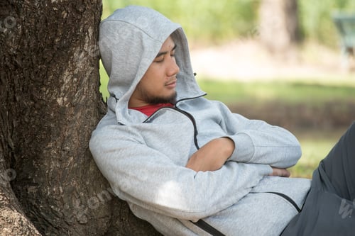 Preview: Asian Man Sleeping Under A Tree After Exercise.