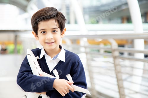 Visualização: Menino segurando o avião na mão com um sorriso.