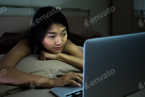 Preview: Beautiful Asian Woman With Attractive Smile While Using Computer Laptop On Bed At Night, Young