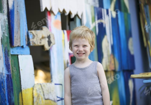 Preview: Boy Standing In Front Of Wooden Boards Painted In Bright Colors.
