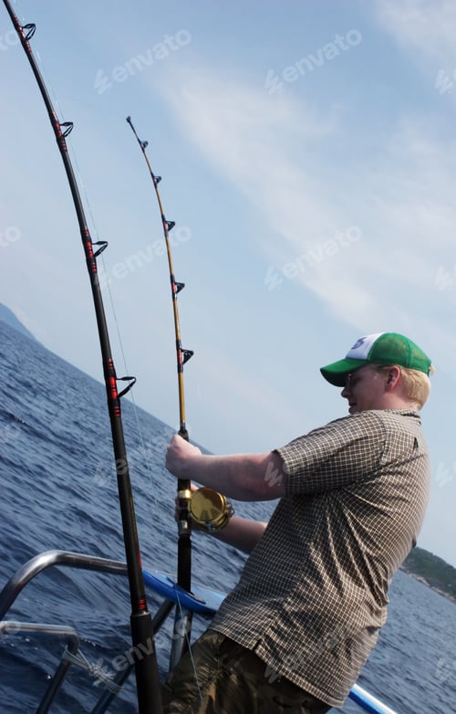 Preview: Man Reeling In A Fish From The Back Of A Boat