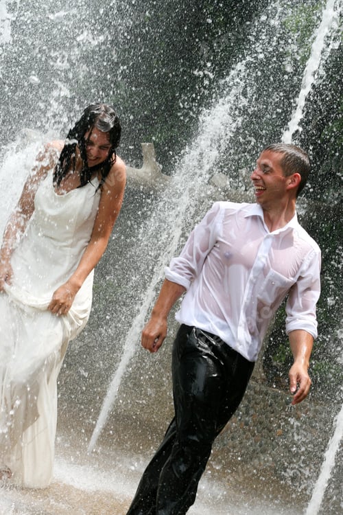 Preview: Bride And Groom Playing Under A Fountain On Their Wedding Day.