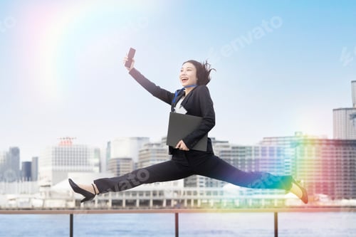 Preview: A Young Business Woman In A Suit Jumping With A Smile