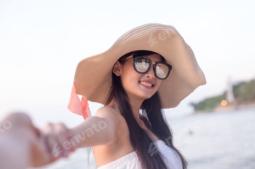 Preview: Portrait Of Happy Young Asian Woman Holding Hand Of Her Boyfriend While Walking At The Beach
