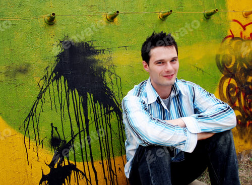 Preview: Young Man Sitting Against A Graffiti Wall.