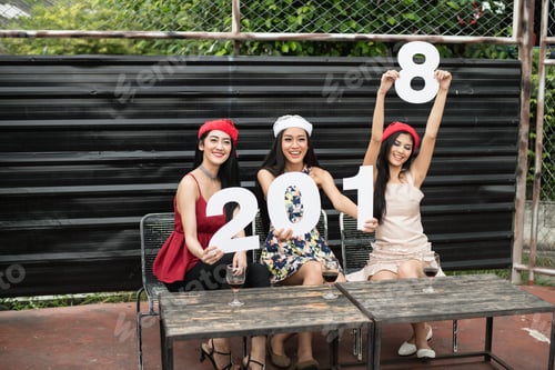 Visualização: Jovens segurando vidros conversam na festa.