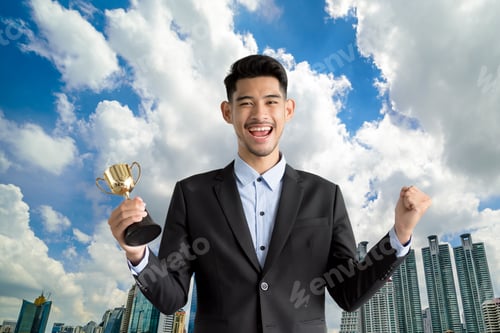 Preview: Handsome Man In A Suit With Prize Cup Over A Cityscape Background