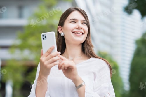 Preview: A Woman Touching And Operating The Screen Of A Smartphone Outdoors