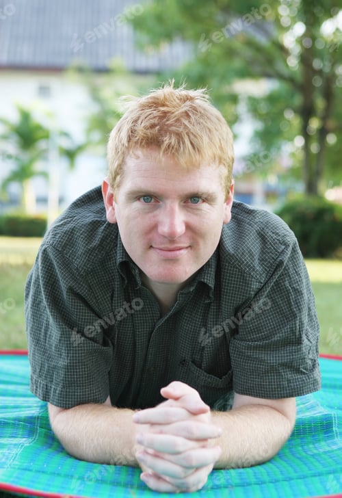 Preview: Man Relaxing At The Park On A Green Mat