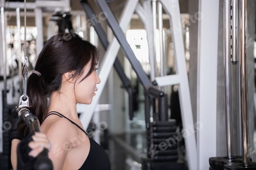 Preview: Exercise Concept. A Beautiful Girl Is Exercising In The Gym. A Beautiful Girl Is Playing A Cable