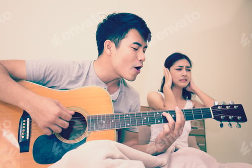Preview: Asian Woman Annoyed At A Man Who Is Singing And Playing A Guitar.