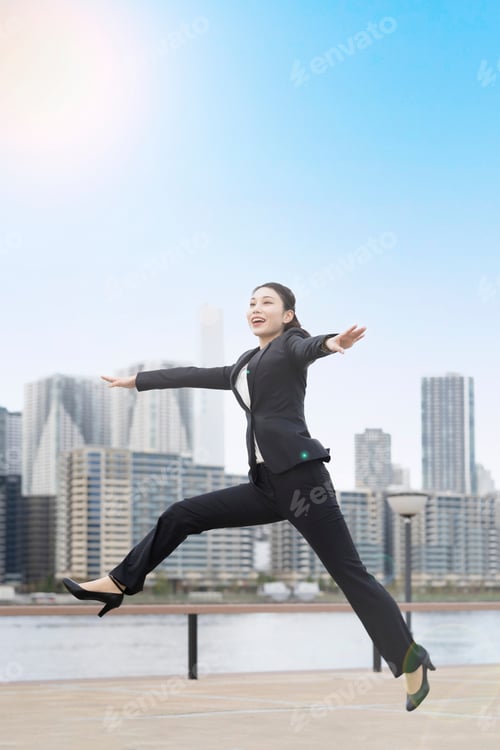 Preview: A Young Business Woman In A Suit Jumping With A Smile