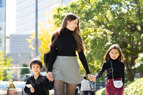 Preview: Mother And Two Children Walking Outdoors Holding Hands With Smile