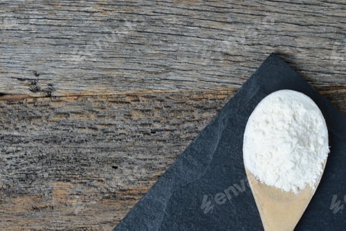 Preview: Wooden Spoon Full Of Flour On Slate Cutting Board And Wooden Background