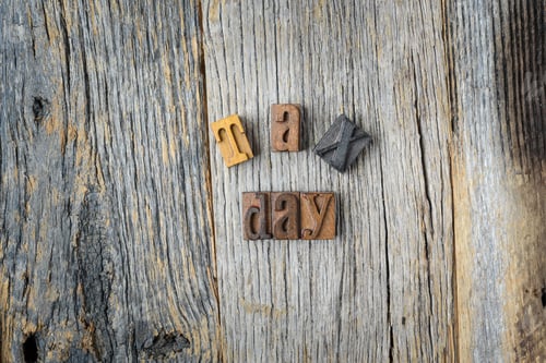 Preview: Tax Day Spelled Out In Wooden Block Letters On Wood Background