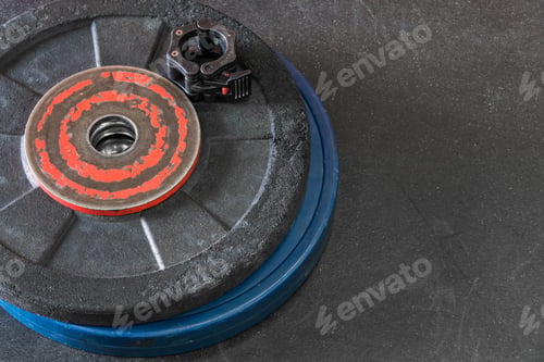 Preview: Rubber Weight Plates And Bar Clip On A Black Gym Floor