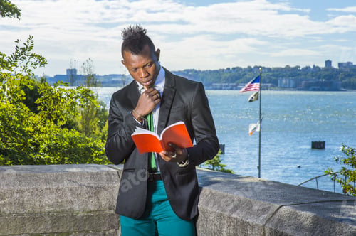 Preview: Young Man Reading Outside. Wearing A Black Blazer, Green Pants, A Green Tie, A Hand Touching Chin