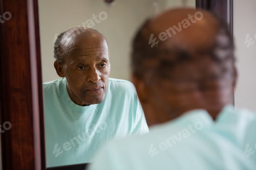 Preview: Mirror With Reflection Of Concerned Senior Man In Bathroom