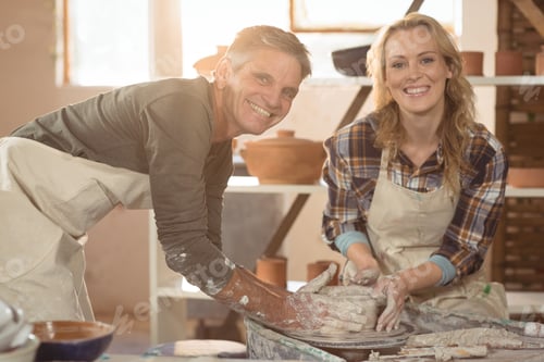 Preview: Portrait Of Male Potter Assisting Female Potter In Pottery Workshop