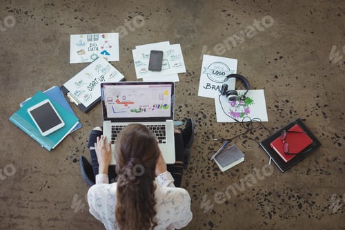 Preview: High Angle View Of Graphic Designer With Laptop Working On Floor At Office