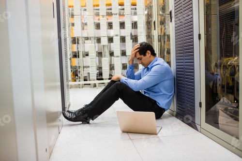 Preview: Stressed Technician Sitting In Hallway Of Server Room