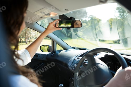 Preview: Beautiful Woman Looking Into Rear View Mirror While Driving A Car