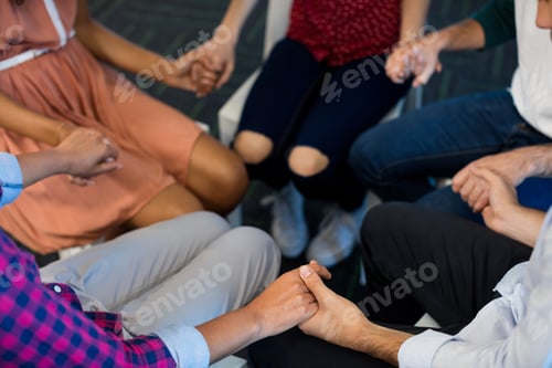 Preview: Mid-Section Of Creative Business Team Holding Each Others Hand At Office